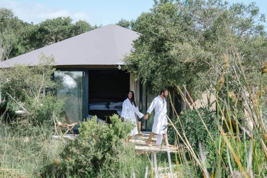 Glamping-tent-couple-heading-off-for-a-bathe-1024x684